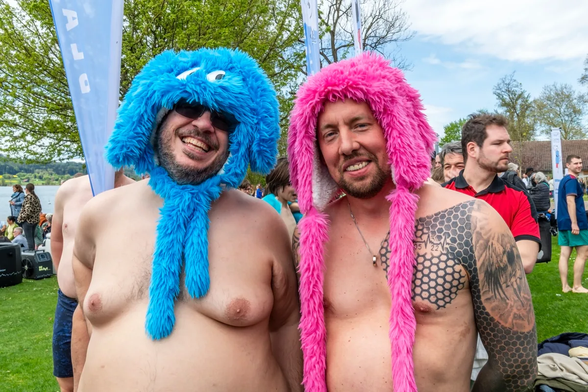 Zwei Männer tragen farbige, fellige Mützen.